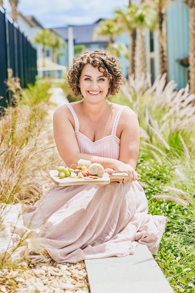 Charcuterie owner holding a grazing board outdoors for personal branding photos