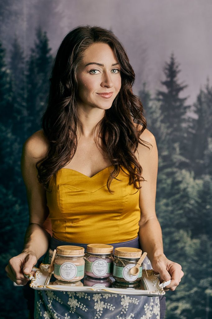 Product-based entrepreneur holding skincare scrubs on a tray for branding photography