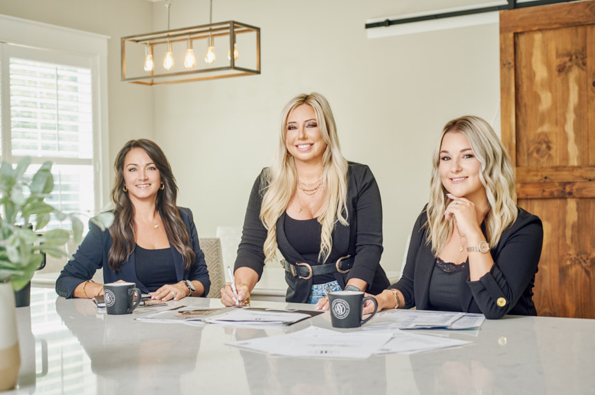 Ashley Yates Realty team at a kitchen island during an Ocala real estate brand photography session